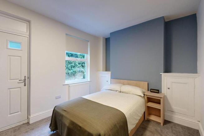 A cozy, well-maintained bedroom with natural li...
