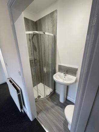 A modern bathroom featuring a curved glass show...