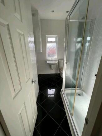 Modern white bathroom with glossy black tiles...