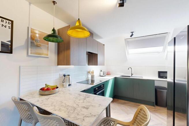 Bright modern kitchen with a marble-effect brea...