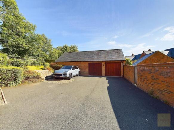 Double garage with driveway parking for multiple vehicles.
