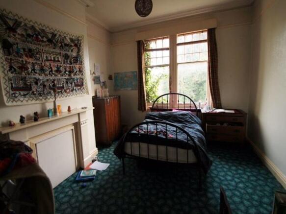 A spacious master bedroom featuring a large win...