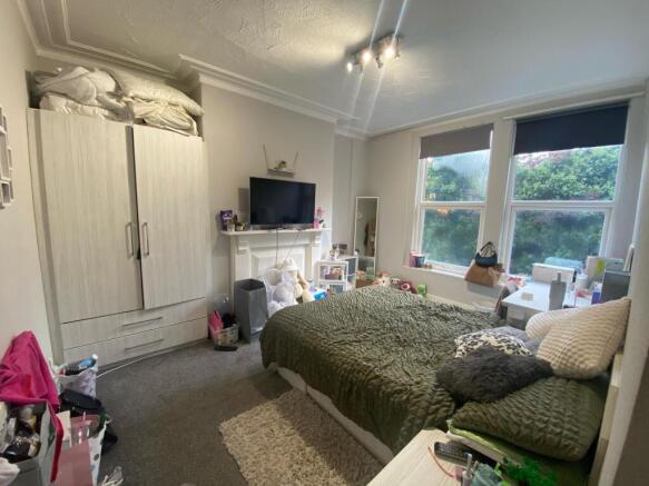 A cozy and well-lit bedroom featuring a large b...