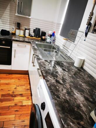 Modern galley kitchen with dark marble-effect w...