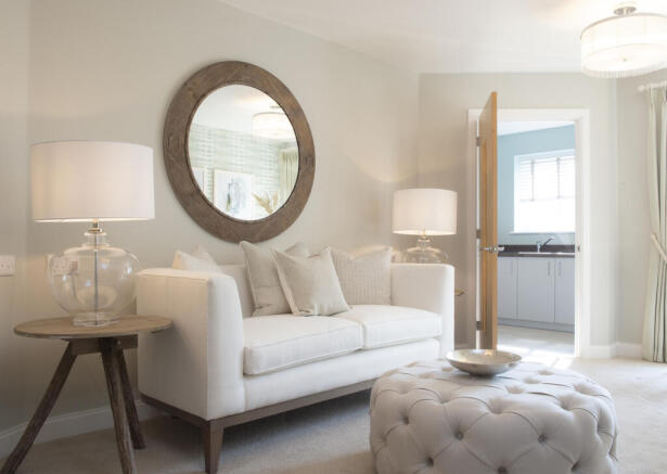 a living room with a white couch and a round mirror