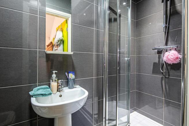 Sleek modern shower room with stylish dark tile...