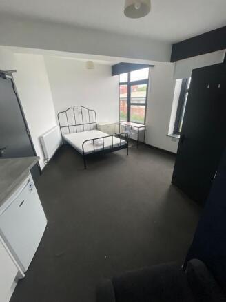 Bright double bedroom featuring large windows t...