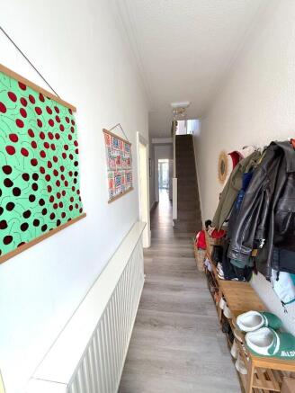Bright and welcoming hallway with wood flooring...