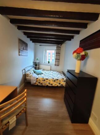 Bright, neatly presented bedroom with exposed c...