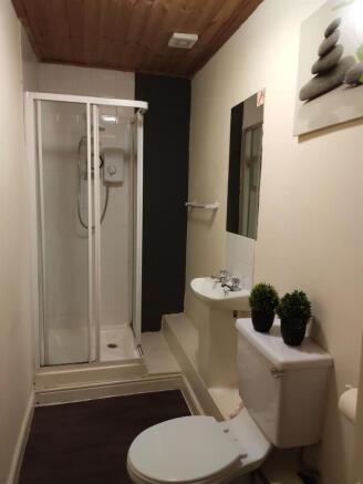 Neat, modern bathroom featuring a glass-enclose...