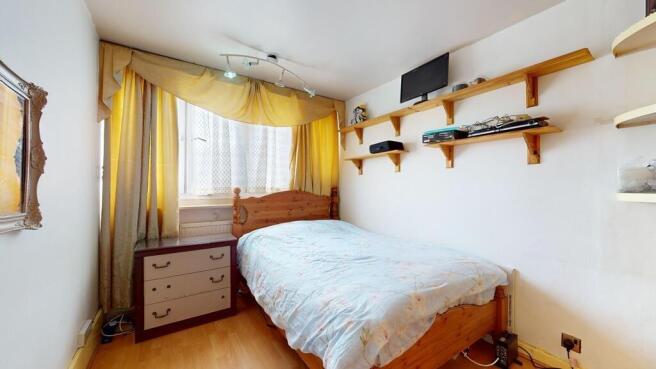 A cozy double bedroom featuring a wooden bed, a...