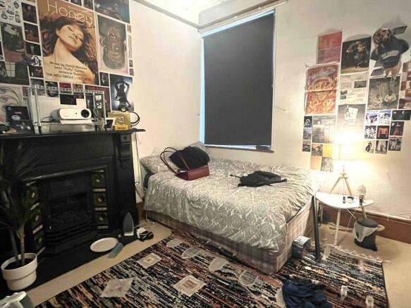 Cozy single bedroom with a decorative fireplace...