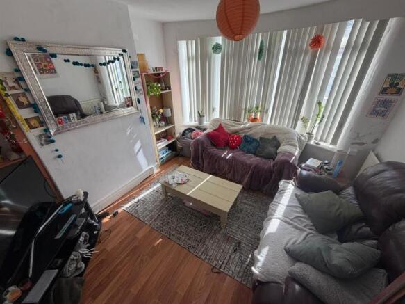 Bright living room with large bay window and so...
