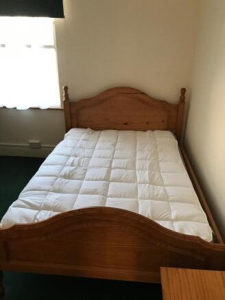 Cozy double bedroom featuring a charming wooden...