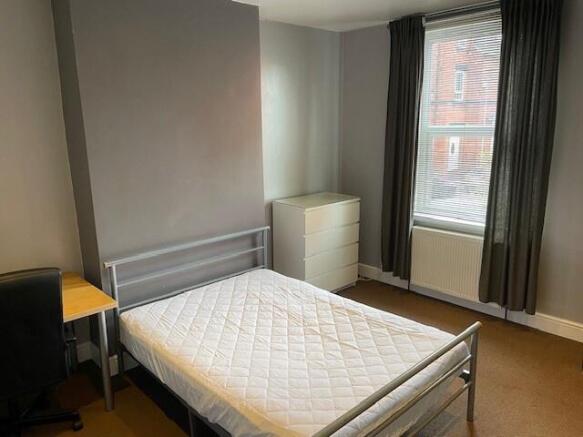 Bright double bedroom featuring a metal frame b...