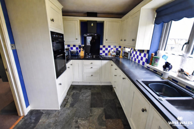 Modern L-shaped kitchen with slate floors.png