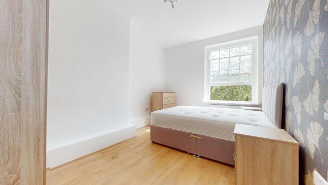 A bright and airy double bedroom featuring a la...