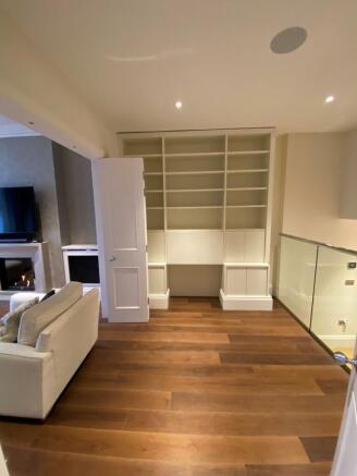 Bright, modern living area with warm wood floor...