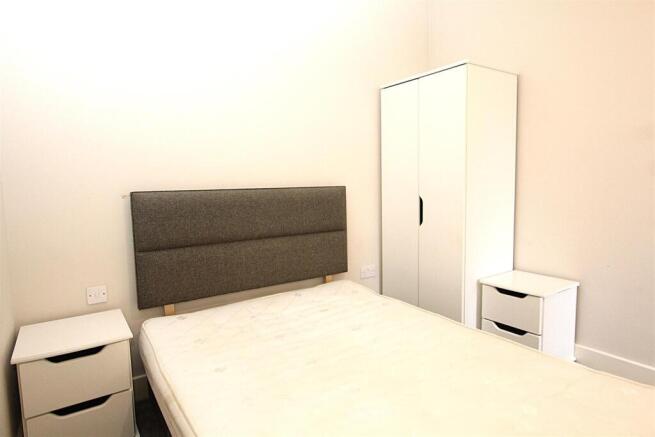 Bright double bedroom with modern white furnitu...