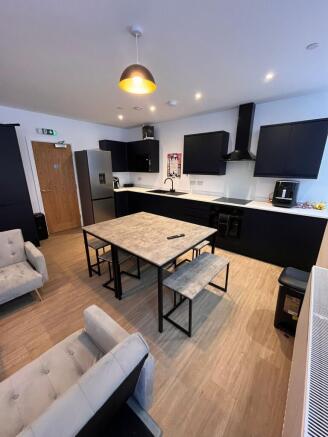 Modern shared lounge-kitchen with a central din...