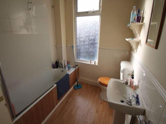 Bright bathroom with a bathtub and shower scree...