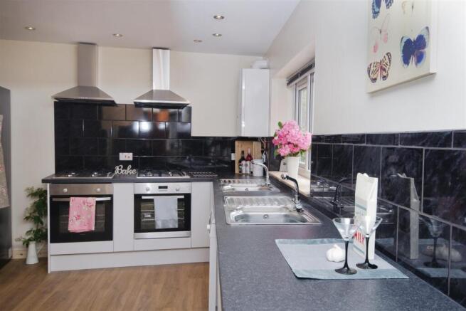 Modern kitchen with dual ovens and sleek tiling...