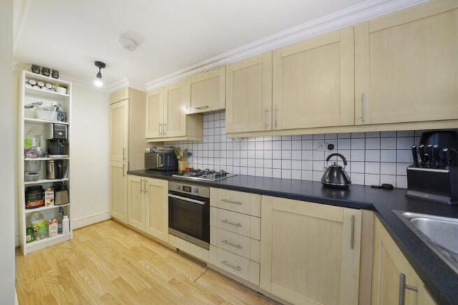 Kitchen with light wood cabinets, black countertop