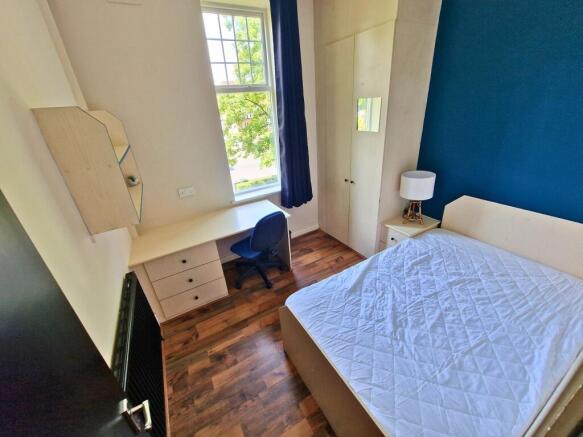 Bright, well-furnished bedroom featuring a comf...