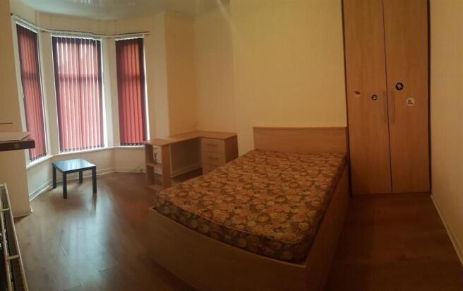 Bright bedroom with a double bed, fitted wardro...