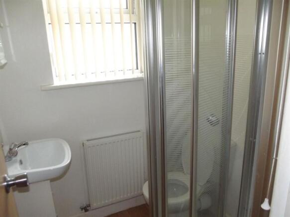 Compact and clean toilet room with a corner sin...