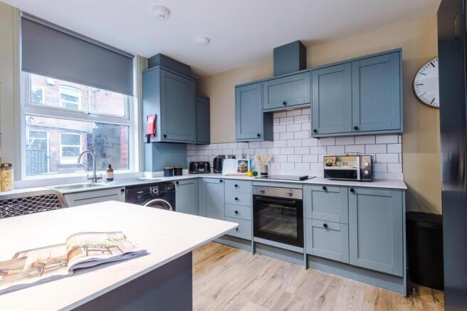 Modern kitchen with blue cabinetry and island...