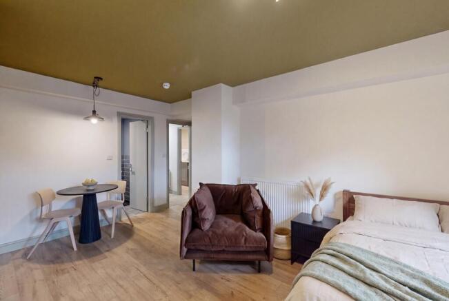 Elegant studio with dining area and plush chair...