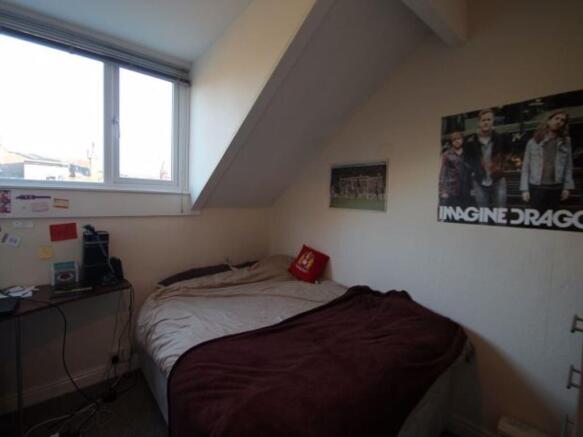 A cozy bedroom featuring a double bed, a window...