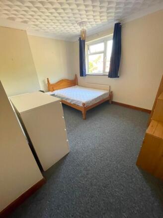 Bright double bedroom with a wooden bed frame, ...