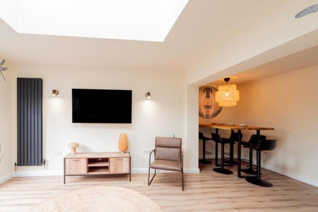 Bright living room with large skylight and bar...