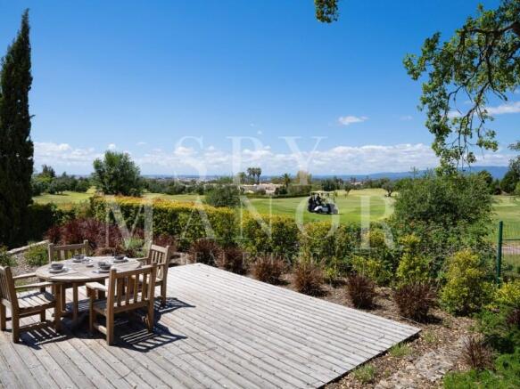 Outdoor wooden terrace with dining area overlooking Gramacho Golf Course and Monchique mountains. Frontline golf villa panoramic views in Algarve.