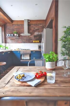 Bright, stylish kitchen with rustic dining tabl...