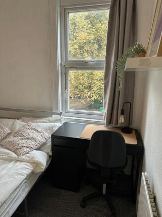 A cozy single bedroom featuring a comfortable b...