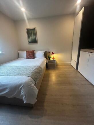 Bright, modern bedroom with a neatly made doubl...