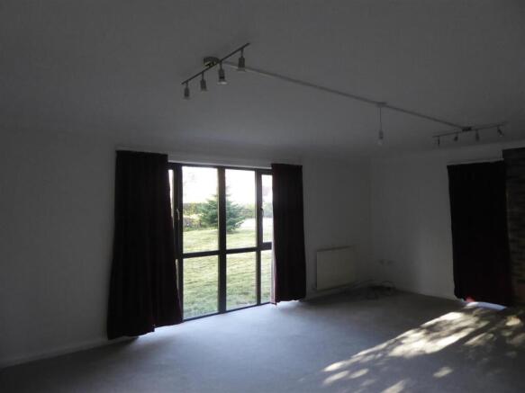 Spacious lounge with large floor-to-ceiling win...