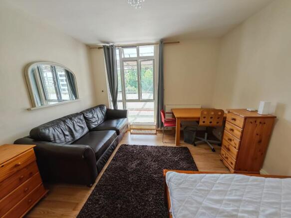 Spacious bedroom with dedicated desk and sofa...