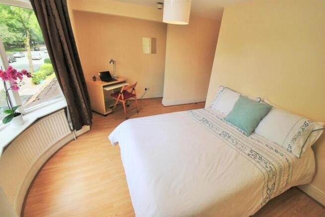 Bright master bedroom with a dedicated desk are...