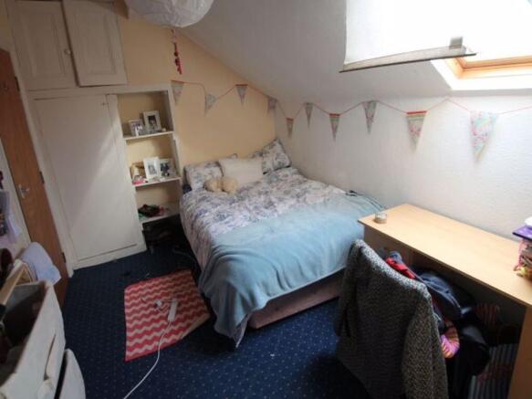 Cozy single bedroom with a neatly made bed, a s...