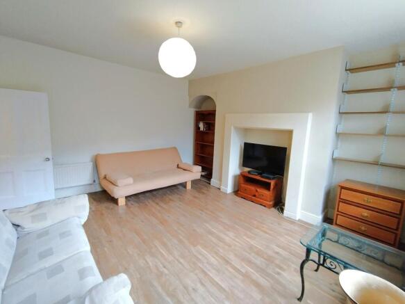 Spacious living area with warm wood flooring...