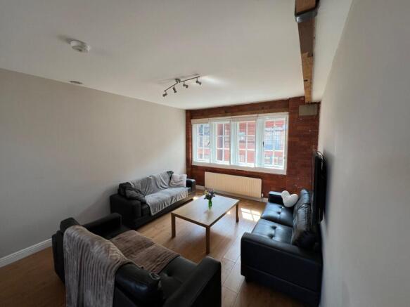 Bright, modern living room with exposed brick f...