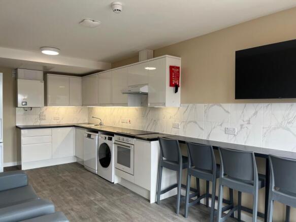 Modern shared kitchen with glossy white cabinet...