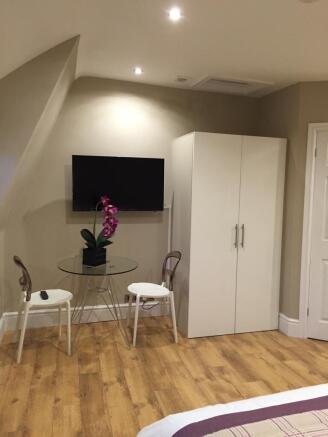 Bright, modern bedroom corner with wood-effect ...