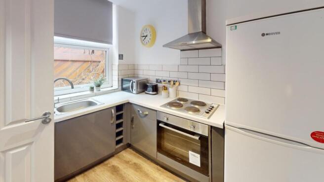 A modern and tidy kitchenette with ample natura...