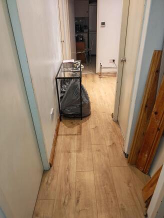 Bright hallway featuring modern wood-style floo...