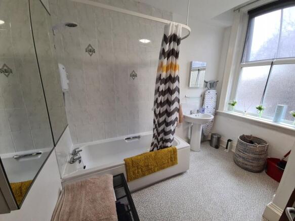 Bright, well-kept bathroom with a full bath and...